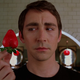 Lee Pace as Ned in Pushing Daisies holds a beautifully ripe strawberry in his fingers.